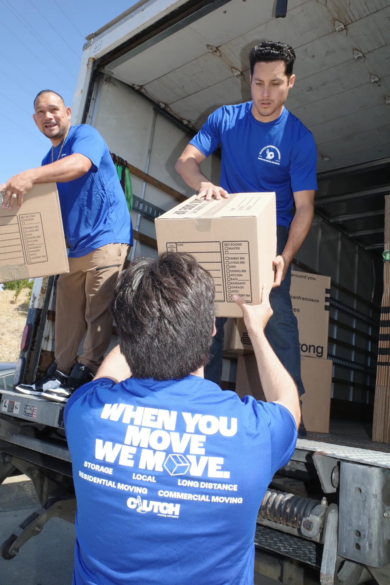 Clutch movers loading moving boxes into a truck